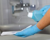 Indications & Use Sites 10 Hospital worker pouring sanitizing solution on a paper towel.