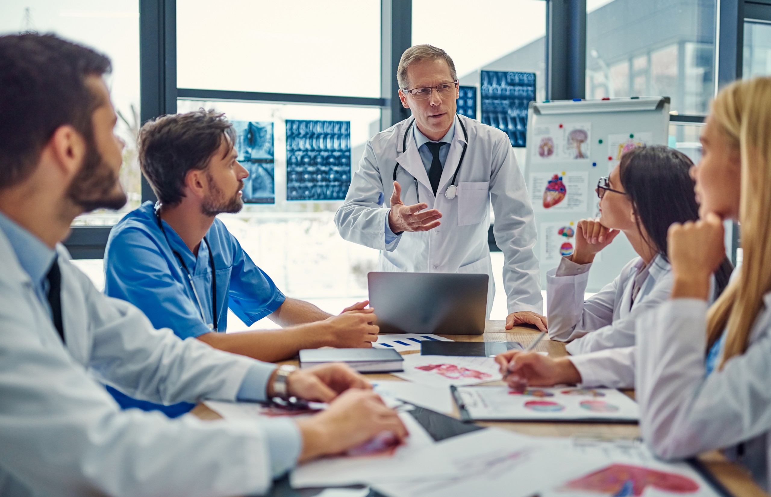 Group of value analysis committee members discussing the benefits of a new medical device.